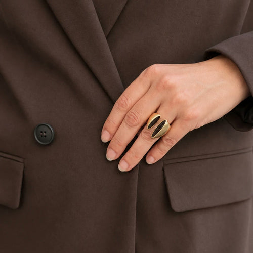 Bague Elia émail marron portée à la main sur une veste brune